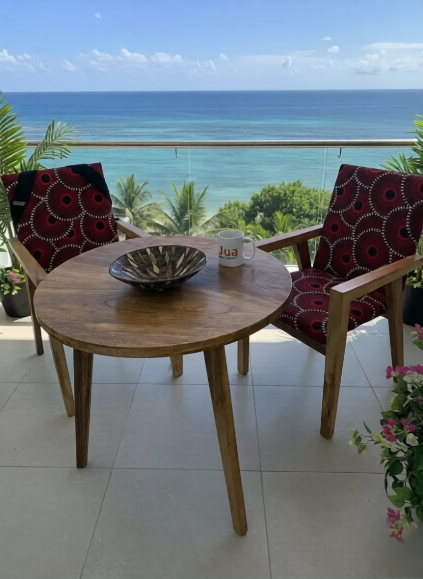 Round wooden dining table and patterned chairs overlooking the ocean