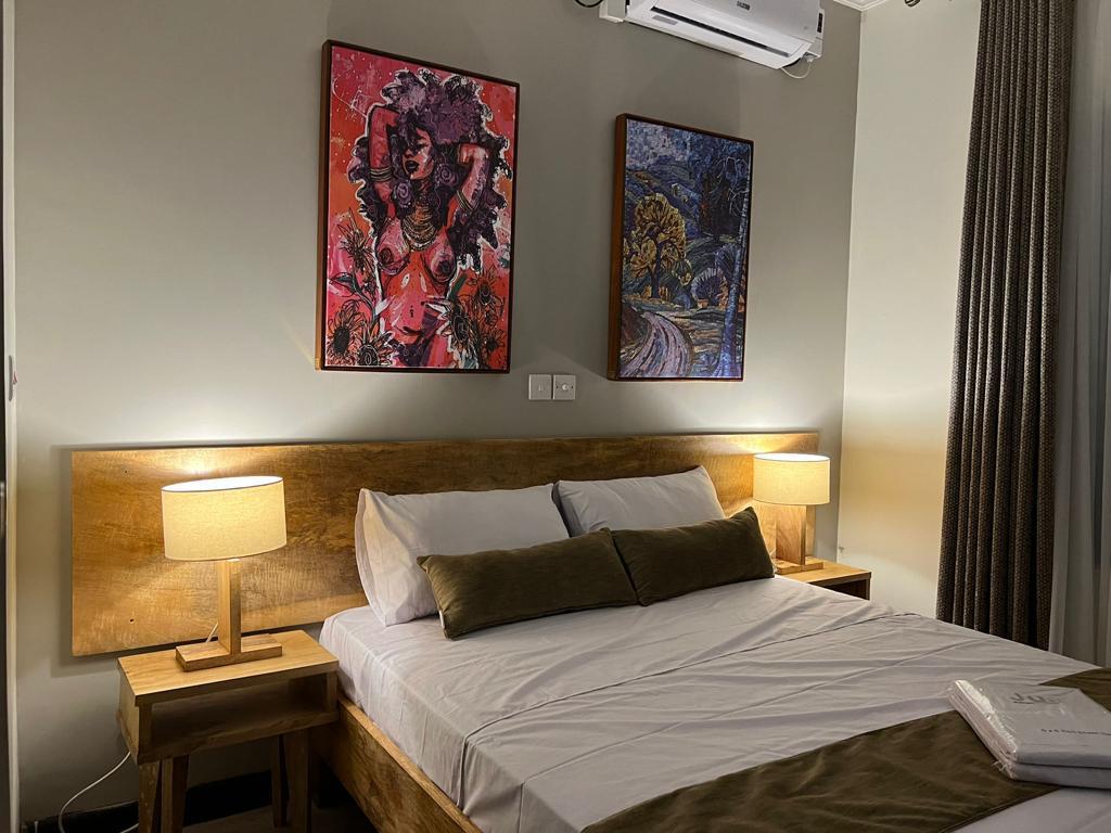 Jua Range bedroom styled with timber furniture, bedside lamps and African art